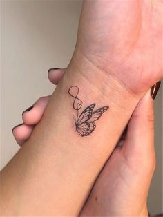 two people holding each other's hands with tattoos on their wrists and one has a butterfly tattoo on the wrist