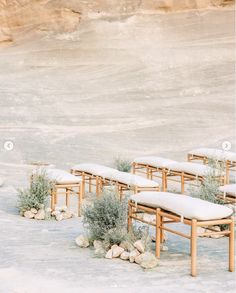 a row of wooden benches sitting next to each other on top of snow covered ground