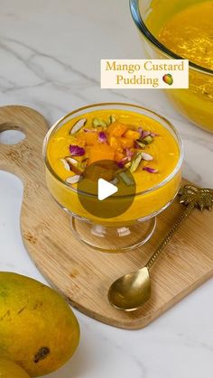 mango custard pudding in a glass bowl on a cutting board next to two pears