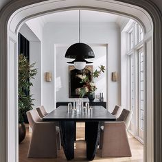 the dining room table is surrounded by green chairs and an oval black chandelier