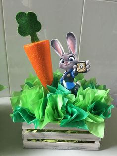 a carrot and bunny figurine sitting on top of tissue paper in a box