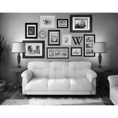 black and white photograph of a living room with couches, lamps and pictures on the wall