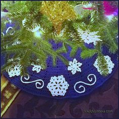 a crocheted blue plate with white snowflakes on it