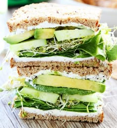 a sandwich with cucumber, lettuce and cheese