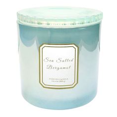 a candle that is sitting on a white surface with the label sea salted bergamot