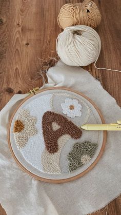 a close up of a embroidery on a table with yarn