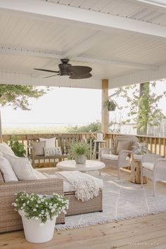 a covered porch with furniture and plants on it