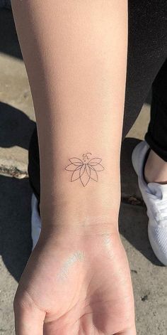 a woman's hand with a small tattoo on the left side of her wrist