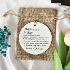 a white ceramic ornament with a poem on it next to flowers and a card