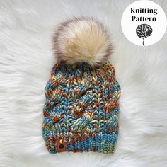 a multicolored knitted hat with a pom - pom on top