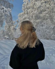 a woman with blonde hair standing in the snow