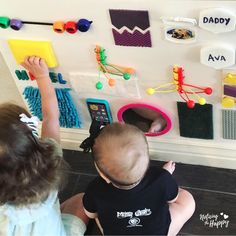 two children are playing with magnets on the wall