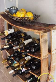 a wooden shelf with wine bottles on top of it and two baskets filled with lemons