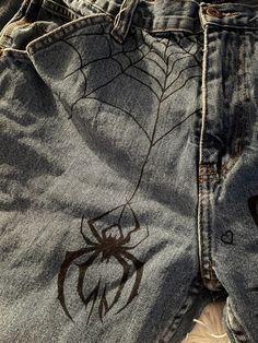 a pair of jeans with spider webs on them