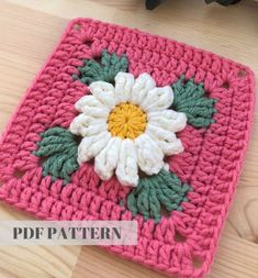 a crocheted square with a flower on it