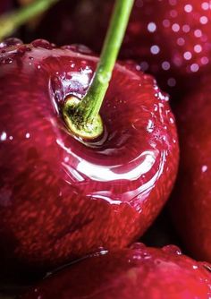 a close up view of some red apples with water droplets on the top and bottom