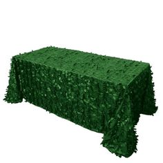 a table covered in green cloth with leaves on the top and bottom, next to a white background