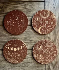 three brown coasters with designs on them sitting on a wooden table next to each other