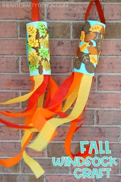 a fall wind sock craft hanging on a brick wall with text overlay that reads, fall windsock craft