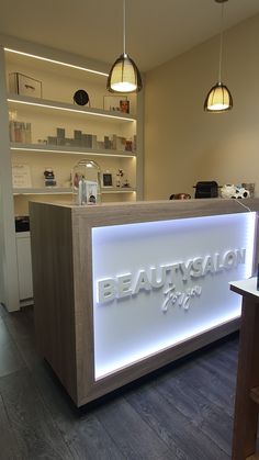 the front desk of a beauty salon is lit up with white lights and wooden shelves