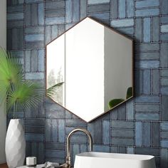 a bathroom sink sitting under a mirror next to a white vase