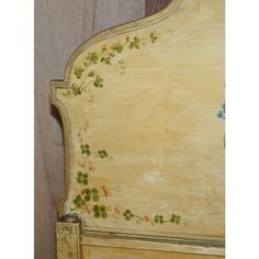 an old wooden bed frame with flowers painted on it