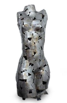 a sculpture made out of metal pieces on a white background with the shape of a woman's torso