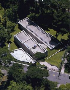 an aerial view of a tennis court in the middle of some trees and grass,