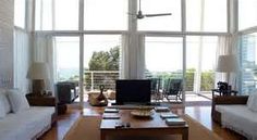 a living room filled with furniture and large windows