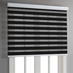 a black and white striped blind hanging on the side of a window