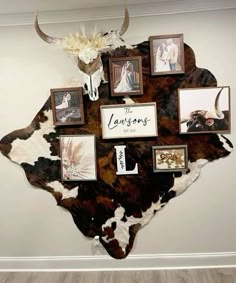 a cow skull mounted to the side of a wall with family photos on it's face