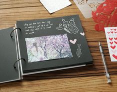 an open photo album on a table with paper hearts