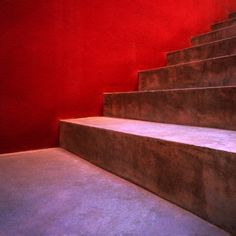 the stairs are made of concrete and have red walls