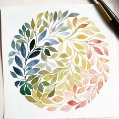 a watercolor painting of leaves on white paper next to a pen and inkbrush