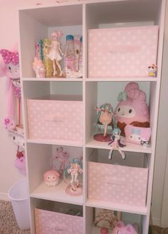 a white shelf filled with lots of pink boxes and stuffed animals on top of it