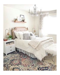 a bedroom with a bed, rug and chandelier