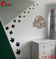 a white dresser sitting in a bedroom next to a wall with black birds on it