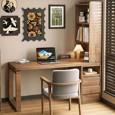 a desk with a laptop on it in front of a bookcase and pictures hanging on the wall