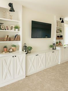 a flat screen tv mounted to the side of a white wall in a living room