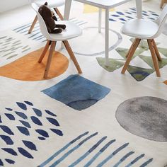 a child's table and chairs are arranged on a rug with an abstract design