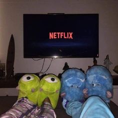 three stuffed animals are sitting in front of a television with the netflix logo on it