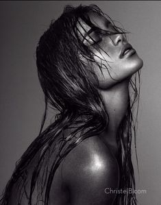 a black and white photo of a woman with wet hair