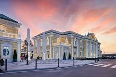 the building is white and has many pillars in front of it at sunset or dawn