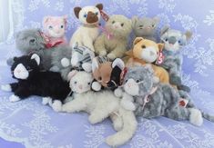 a group of stuffed animals sitting on top of a blue cloth covered tablecloth with snowflakes in the background