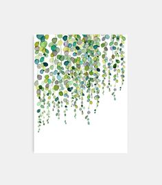 an abstract painting with green and blue circles on white paper, hanging from the ceiling