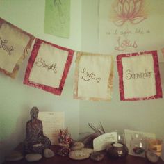 some towels hanging on a wall above a table with candles and other items in front of it