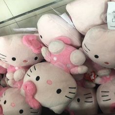 a pile of hello kitty stuffed animals sitting on top of each other in a store