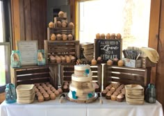 a table topped with lots of cakes and cupcakes on top of wooden crates