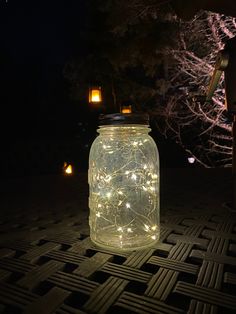 a mason jar filled with fairy lights sitting on the ground