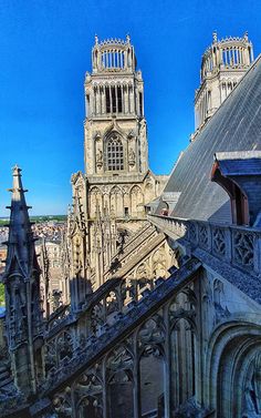 an old cathedral with steeples and blue sky in the background